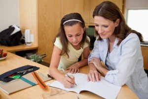 How to Get Top Marks With Your Start-Up Tutoring Business - image - female teacher with girl student at a desk