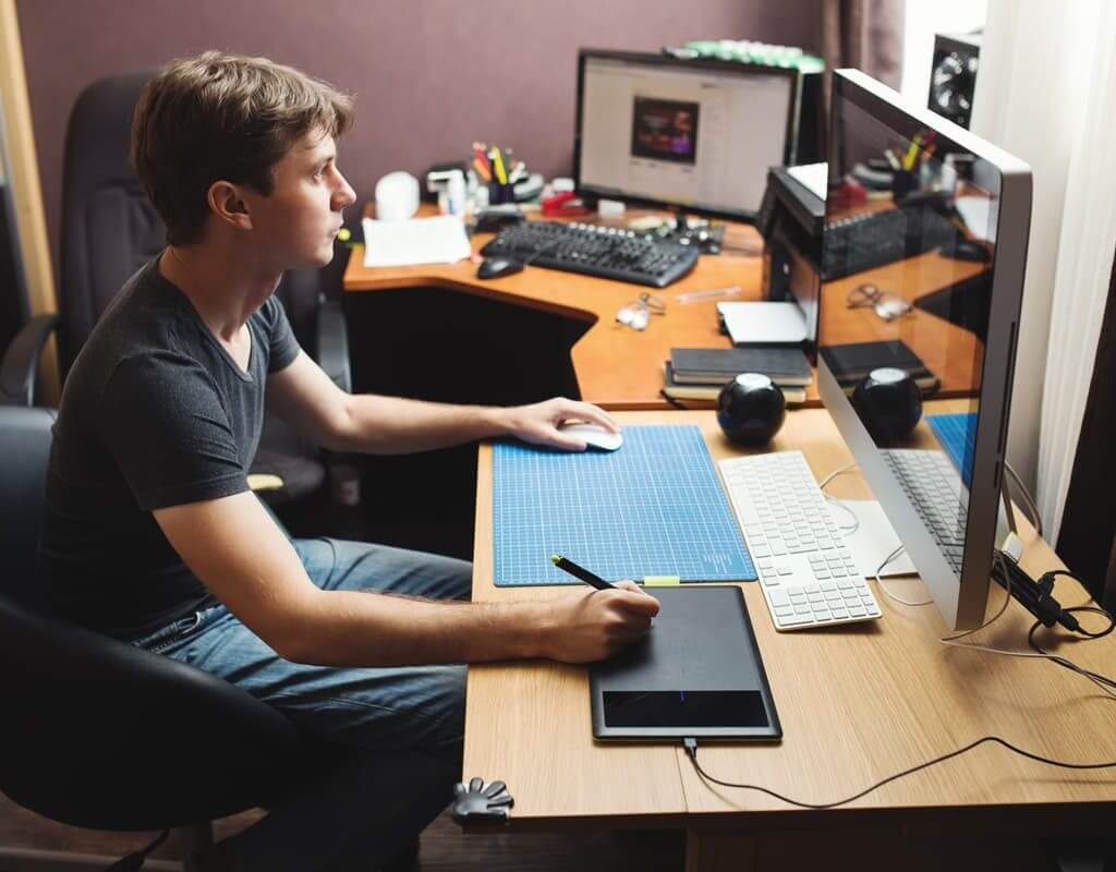 Young freelancer working from home on a desktop computer