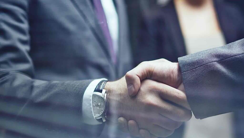 Business men wearing suits conducting a handshake