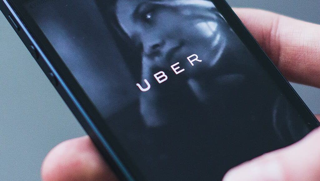 What Is the Uber Ruling and How Will It Affect Small Businesses? image - hand holding phone with uber app open